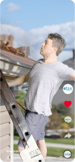 A man stands on a ladder, surprised, as he cleans leaves from a house gutter. He wears a gray t-shirt and shorts. Social media icons and the text "@etaxaccountants" are overlaid on the image.