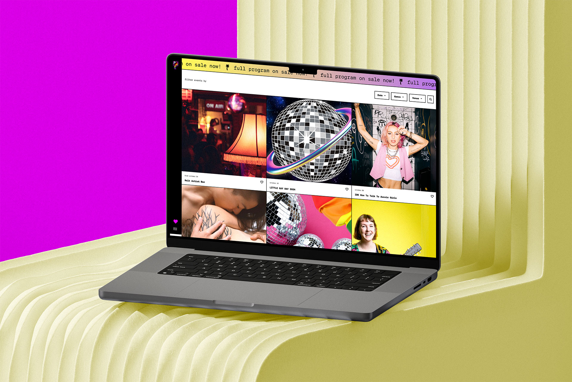 A laptop on a textured cream surface displays a colorful website with disco balls, a woman singing, and event graphics. The background is split pink and cream.