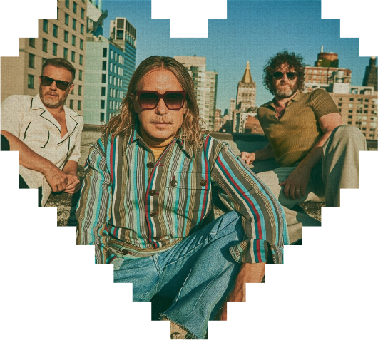 Three men wearing sunglasses pose on a city rooftop, with tall buildings and a blue sky in the background. The image has a pixelated heart-shaped border.