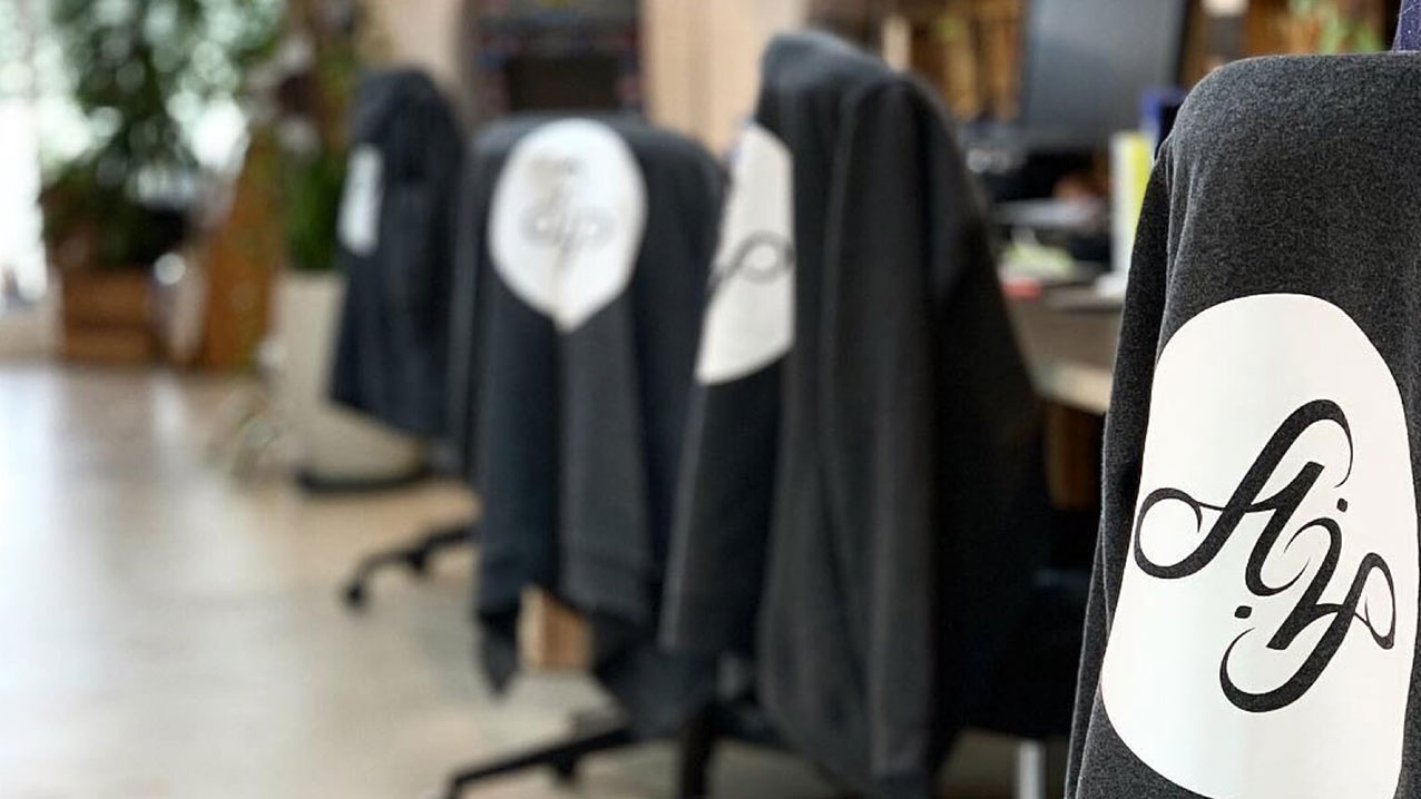 Office chairs with branded sweatshirts draped over them