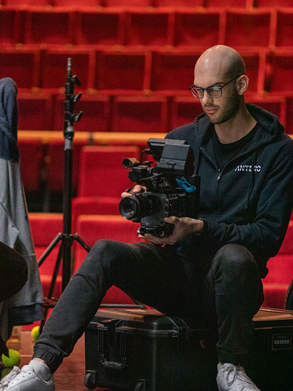 Person adjusting a professional video camera in a theater