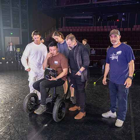 Production crew reviewing camera footage on a theater stage
